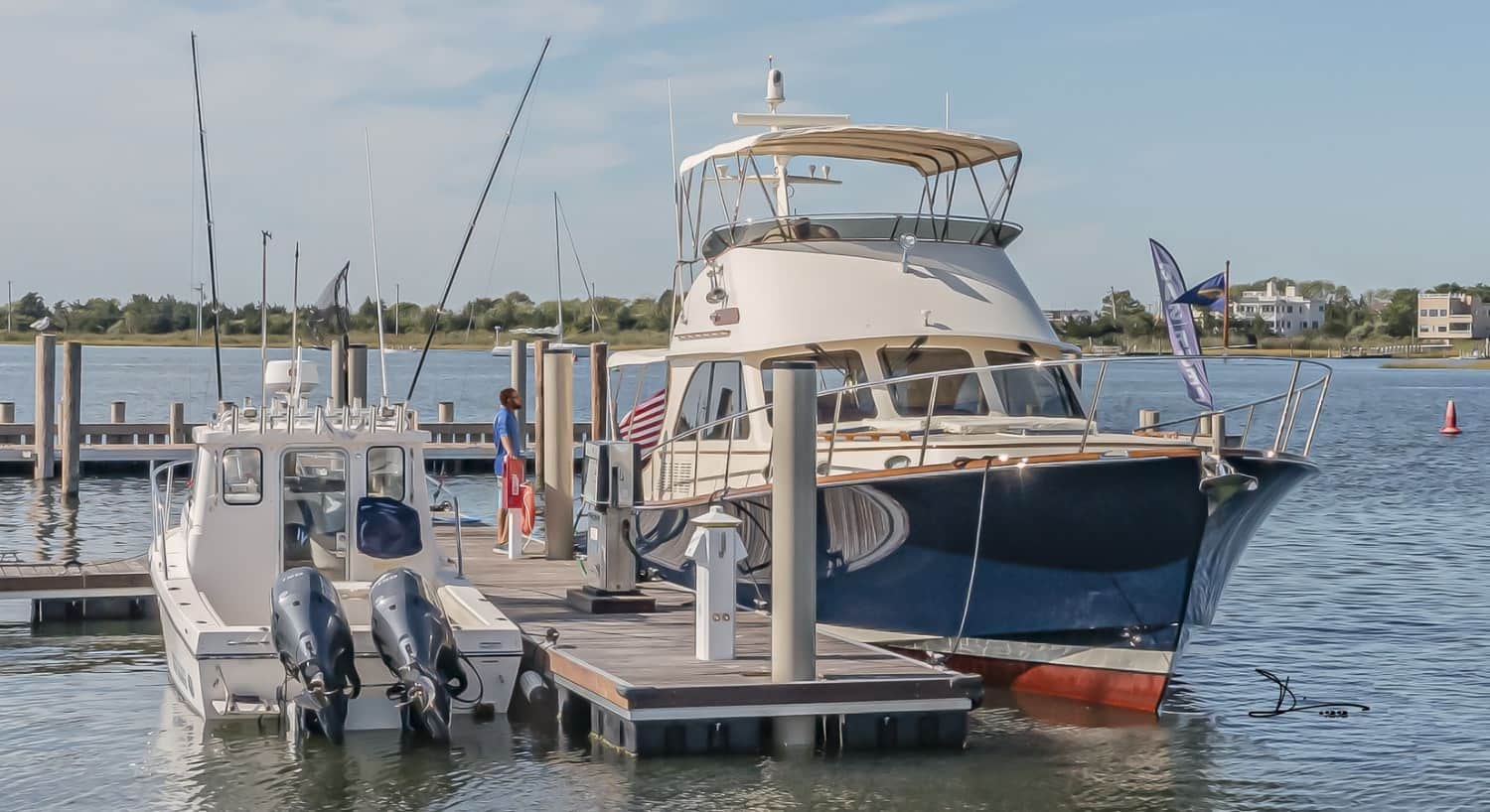 White and blue sailing motor yacht named Darling docked in a marina