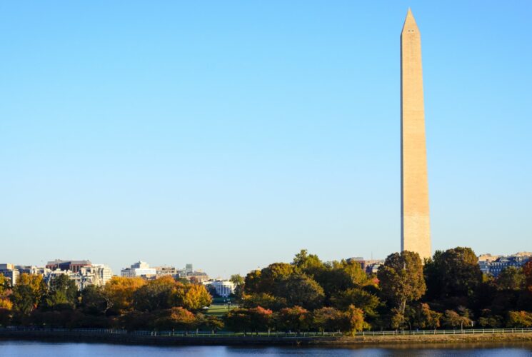 Washington monument surrounded by green trees and near the Potomac river